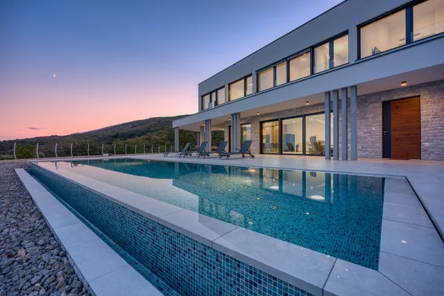 Illuminated pool beside the villa at dusk