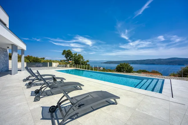 Sun loungers beside the pool overlooking the sea