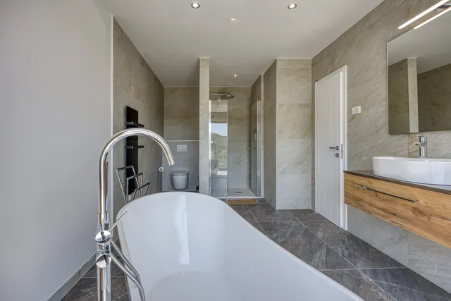 Bathroom with a freestanding bath and warm wood details