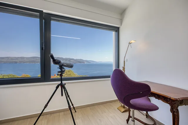 Window-side corner with a telescope and sea view