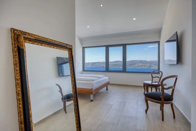 Bedroom and sea view reflected in a mirror