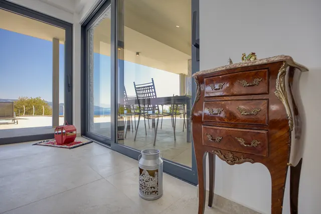 Meuble ancien près des baies vitrées donnant sur la terrasse